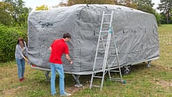 Die Schutzhülle wird von vorne nach hinten über den Caravan gezogen.