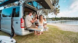 Familie, Caravan, Camping Young Family Enjoying Outdoor Meal by Scenic Sea