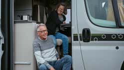 Mature couple looking outside camper van Mature couple looking outside camper van
