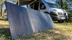 Solarpanel, Campingbus, Photovoltaik, Camping, Stromversorgung, Outdoor, Vanlife, Solarmodul, Energieversorgung, Wald Tragbares Solarpanel auf dem Boden vor einem Campingbus im Wald.