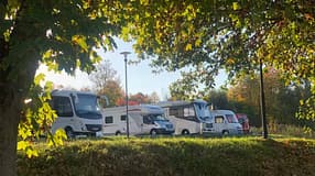 Reisemobile stehen unter Bäumen im Wohnmobilhafen Idstein.