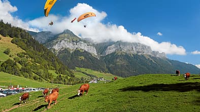 Gleitschirmflieger am Bergmassiv La Tournette über dem Col de la Forclaz