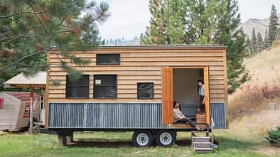 Young couple talking in doorway of their tiny house