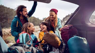 Young family getting the camping supplies out of the car