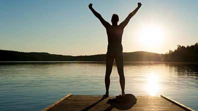 A man stretches his arms on a jetty