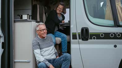 Mature couple looking outside camper van Mature couple looking outside camper van