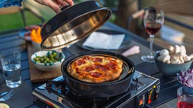 Omnia Stovetop Pizza Oven in Benutzung draußen beim Camping