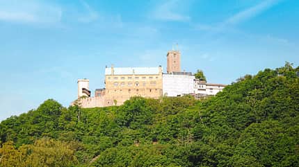 Deutschlands Mitte, Immer mittendrin, Eisenach, Wartburg, symbolischer Mittelpunkt Deutschlands Hoch über Eisenach ragt die Wartburg als symbolischer Mittelpunkt Deutschlands empor.