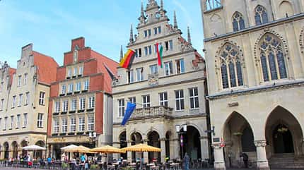 Münsterland, Prinzipalmarkt, Münster, beflaggtes Stadtweinhaus, 1615, Rathaus, Am Prinzipalmarkt von Münster steht das beflaggte Stadtweinhaus von 1615, rechts daneben das Rathaus