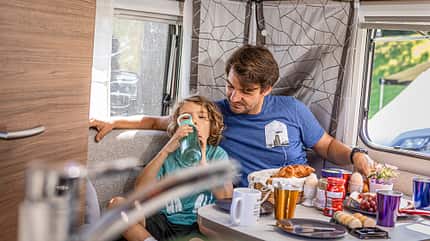 Electro, Camper, Caravan, Zugwagen Elektro-Camping Vater und Soohn beim Essen