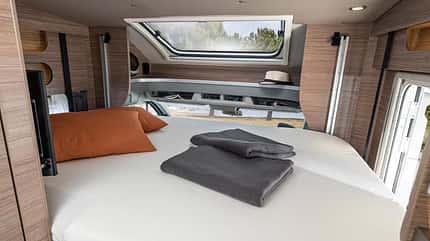 Seitenansicht, Ford Transit, Carasuite, Weinsberg, Wohmobil Hubbett, Doppelbett, T-Haube, Teilintegriert, Fenster, Kissen, Decke