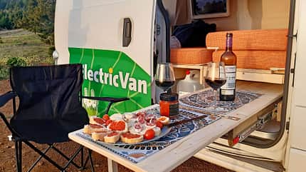 Ausziehtisch, Klappstuhl, Essen, Weingläser, Elektro-Camper Ausziehtisch, Klappstuhl, Essen, Weingläser, Elektro-Camper