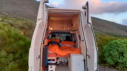 Elektro-Camper, Interieur, Bett, Decke, Mann, Hügel Elektro-Camper, Interieur, Bett, Decke, Mann, Hügel