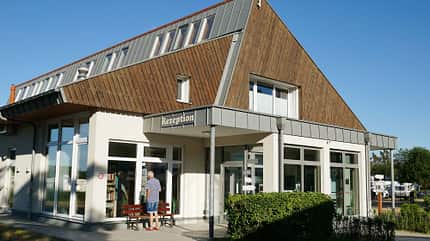 ZentralgebŠude, Bank, Mann, Hecke, Himmel ZentralgebŠude, Bank, Mann, Hecke, Himmel