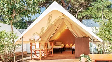 camp,canvas,outdoor,interior,romantic,retreat,wooden,white,campsite,vintage,accommodation,experience,countryside,cabin,lodge,light,tipi,trip,background,bed,holiday,vacation Glamping open tent with cozy interior on a sunny day. Luxury camping tent for outdoor summer holiday and vacation. Lifestyle concept