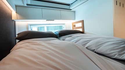 Bett, Matratze, Fenster, Platz für zwei Personen, Dachstauschränke Schlafbereich im GLOBAL XRS 7400 LEOPARD mit Doppelbett, Dachstauschränken und Fenster, Luxus-Wohnmobil-Bett
