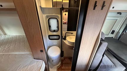 Bad, WC, Schwenkwand, zwischen Bett und Sitzgruppe Nasszelle im Hobby ONTOUR VAN – Schwenkbad mit WC und Dusche zwischen Bett und Sitzgruppe, platzsparende Campingbus-Ausstattung.