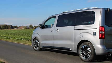 Außenaufnahme, Fahrerseite, Seitansicht, Fahrt, Opel Zafira DAILYCAMPER VAN Seitansicht – Opel Zafira Basis, 180 PS Diesel, Automatik, Voll-LED-Scheinwerfer, Parksensoren, offene Schiebetür, Frau steigt ein
