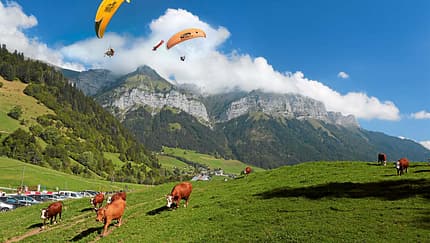 Gleitschirmflieger am Bergmassiv La Tournette über dem Col de la Forclaz
