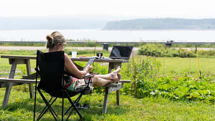 Workation beim Camping, Frau in Faltstuhl