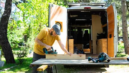 Man customizing his handcrafted camper van