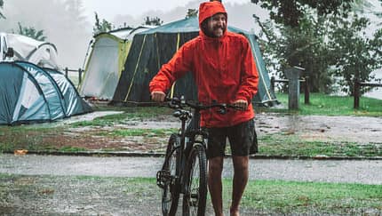 Mountain biker coming back to camping under a rainstorm