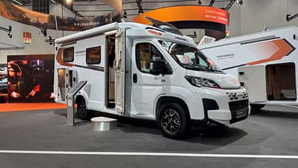 Hotel-Feeling statt Wohnwagen: Queen-Bett mit Lederkopfteil und Retro-Ventilatoren. Weinsberg CaraCompact Edition Pepper 580 MEG 2031