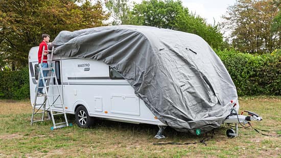 Die Schutzhülle wird von vorne nach hinten über den Caravan gezogen.
