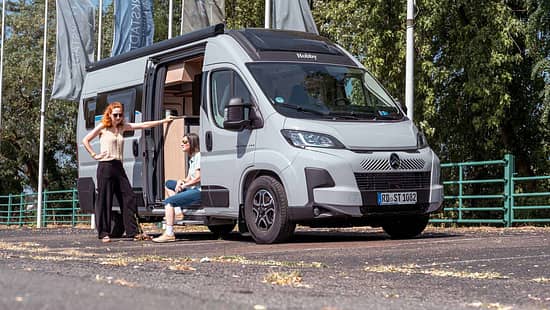 Zwei Frauen vor Hobby ONTOUR VAN 600 FT – Campingbus mit geöffneter Aufbautür, Vanlife-Alltag und Reisevorbereitung.