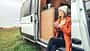 open door,pom pom hat Woman drinking coffee sitting at the door of a campervan