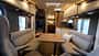 Carthago C2-tourer I 146 FF-RB-LE (2027) Die Face-to-Face-Sitzgruppe mit Blick auf weiteren Wohnraum im Wohnmobil Carthago C2-tourer I 146 FF-RB-LE.