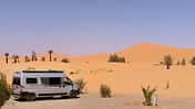 Wüstenlandschaft, Campingvan, Palmen, Büsche, Sand, Himmel