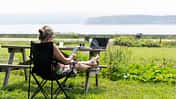 Workation beim Camping, Frau in Faltstuhl
