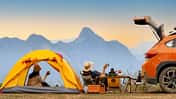 Campingszene mit orangener Zeltmontur und Carcamper