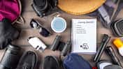 Symbolbild Packliste Festivalcamping: Campingzubehör und Notizzettel