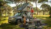 Zurück zur Natur: Prime Tech Delta Dachzelt zwischen hohen Bäumen, Leiter ausgeklappt, zwei Frauen genießen das Camping-Setup. Waldluft, Vogelgezwitscher und das Dach über dem Kopf – so schmeckt Freiheit.