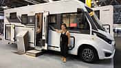 Benimar Amphitryon A968 (2027), Außenansicht, Beifahrerseite, Frau, Messe, Caravan Salon 2026 Außenansicht des Benimar Amphitryon A968 (2027) auf dem Caravan Salon 2026, Beifahrerseite mit Frau als Größenvergleich.